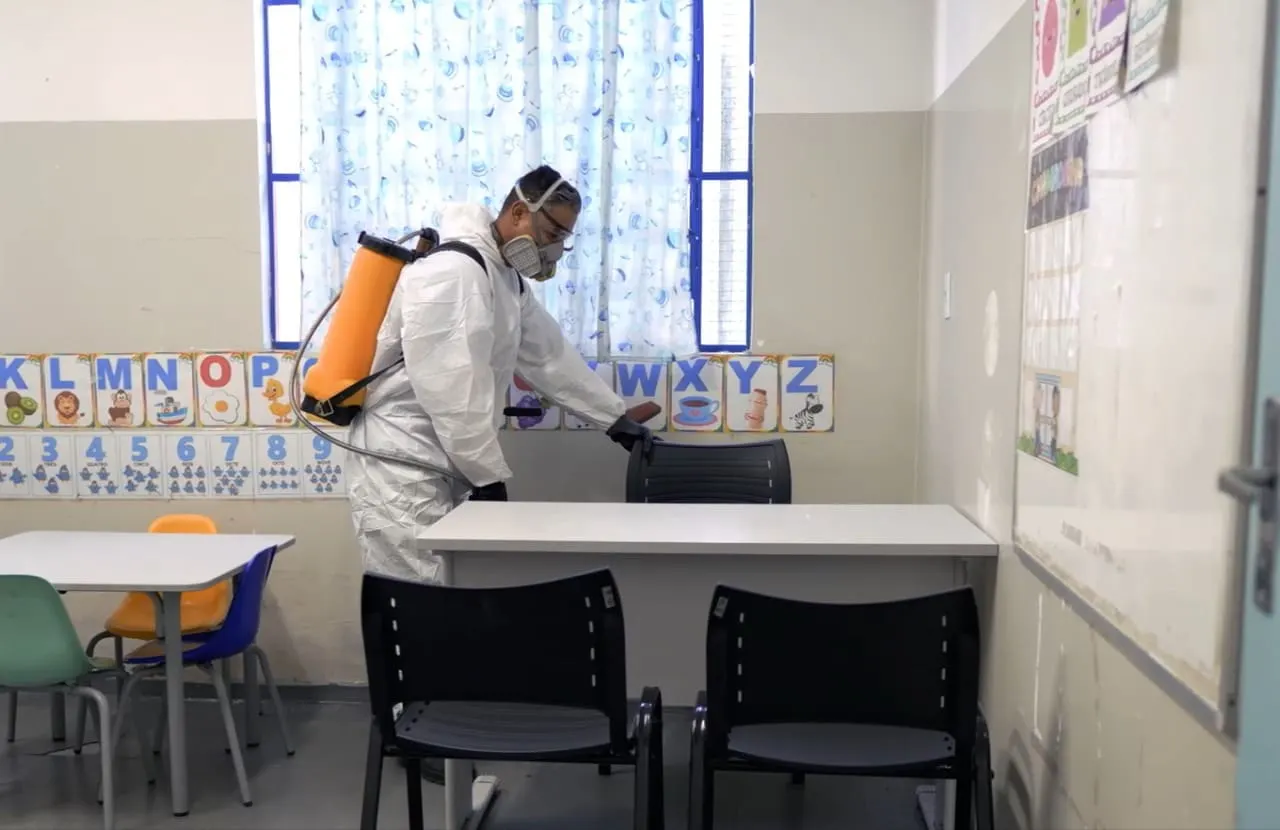 Técnico da Ducktec aplicando em sala de aula, com EPI completo